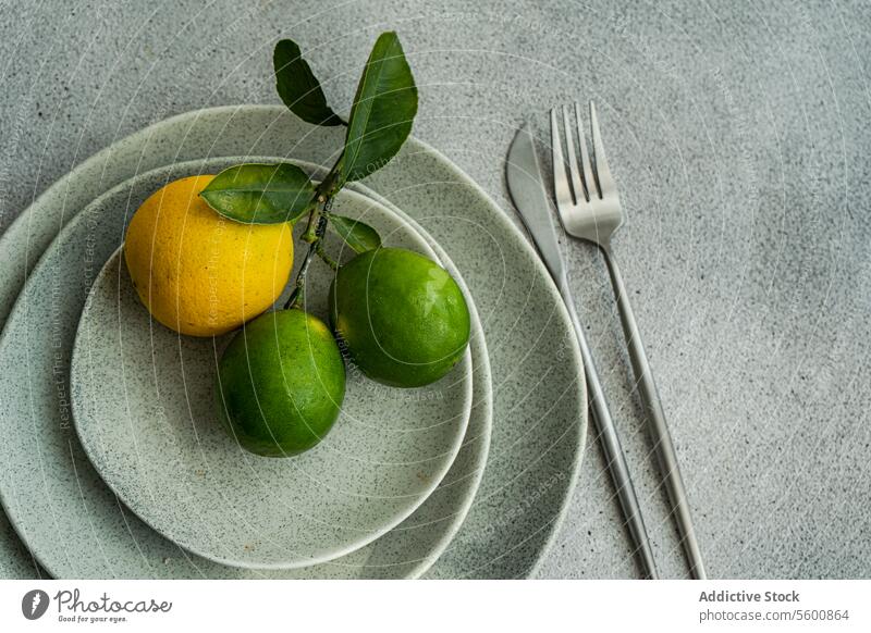 Zitrusfrüchte auf gestapelten Keramiktellern Früchte Platten modern Küche Ästhetik natürlich Urelemente Overhead Zitrone Kalk grün gelb Geschirr minimalistisch