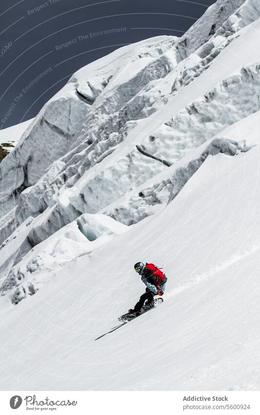 Anonymer Mann mit Skiern und Snowboard fährt über verschneites Land im Urlaub in den Schweizer Alpen Schnee Landschaft Berge u. Gebirge anonym Ganzkörper