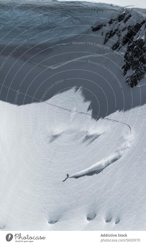 Hohe Winkel der unerkennbaren Person Skifahren auf Schnee Berg während des Urlaubs in den Schweizer Alpen während des sonnigen Tages Skifahrer Berge u. Gebirge