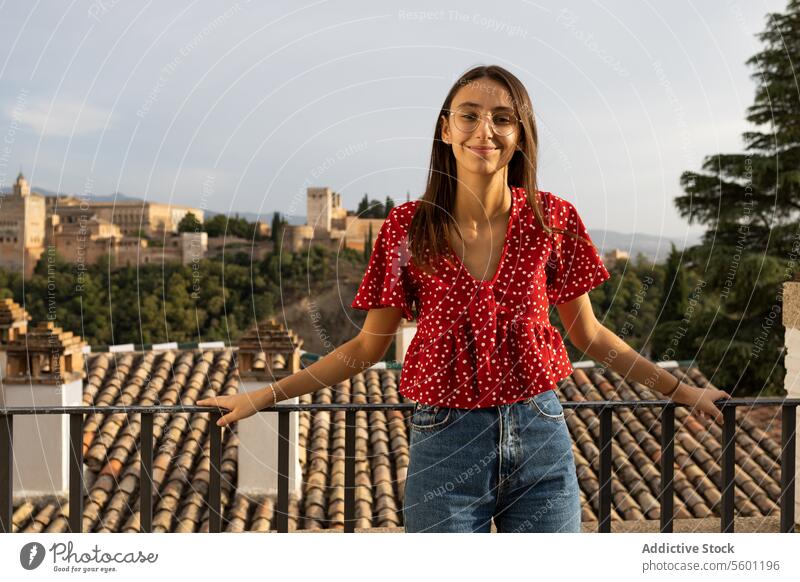 Glücklicher Tourist, der am Geländer der historischen Alcazaba steht, während er seinen Urlaub in Granada, Spanien, genießt Frau Brille Lächeln Freizeitkleidung