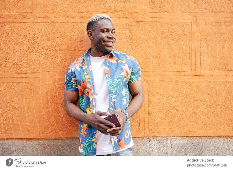 Porträt eines jungen schwarzen Mannes auf der Straße Lächeln Fröhlichkeit urban Afrikanisch Großstadt Lifestyle männlich Person Erwachsener Typ Smartphone