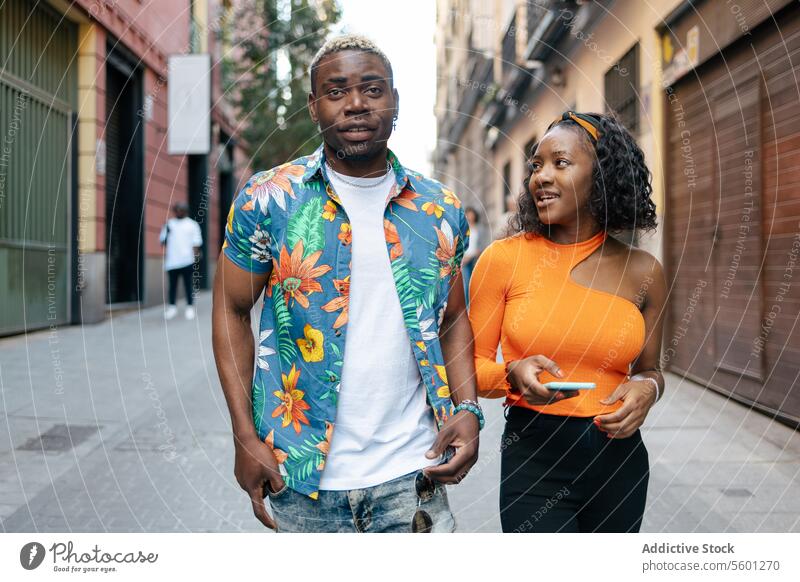 Junge schwarze Freunde gehen auf der Straße jung Paar Lächeln Smartphone Glück Lifestyle im Freien Telefon Mobile Technik & Technologie urban lässig Mann Frau