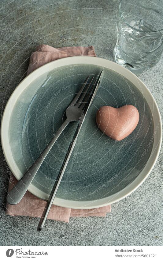 Valentinstag-Tisch mit Herz-Kristall-Dekor auf Betonoberfläche am Küchentisch Teller Keramik Liebe Valentinsgruß Geschirr Kulisse Oberfläche Besteck Essgeschirr