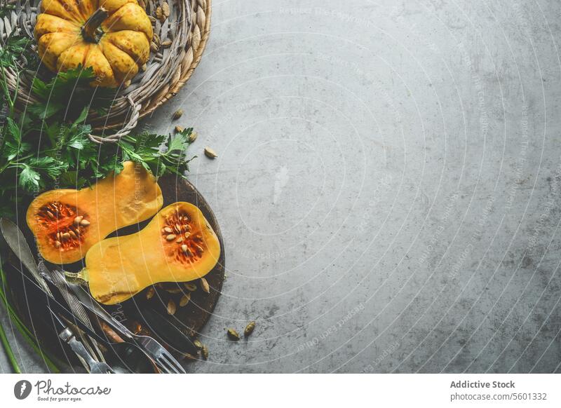 Gesundes saisonales Essen Hintergrund mit Kürbissen, frischen Kräutern und Besteck auf rustikalem Hintergrund, Ansicht von oben. Umrandung Gesundheit