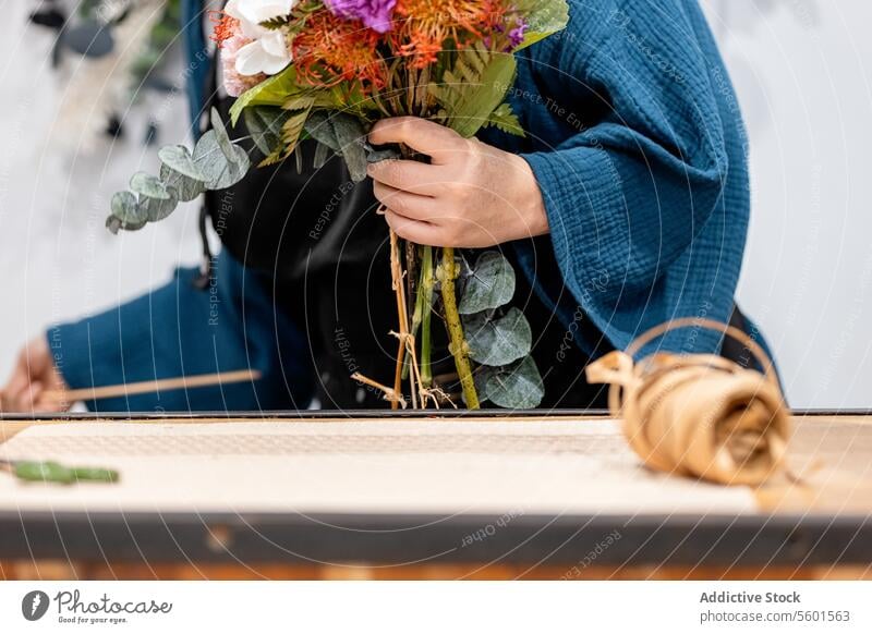Anonyme Person beim Basteln eines Blumenstraußes mit Blumen Blumenhändler Ordnung Hobelbank Hand Handwerk Design geblümt Gartenbau Hobby Beruf kreativ Natur