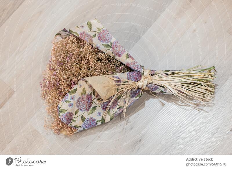Handgemachter Lavendelblumenstrauß auf Holzboden handgefertigt Blumenstrauß Trockenblume geblümtes Papier hölzern eingewickelt Dekoration & Verzierung Handwerk