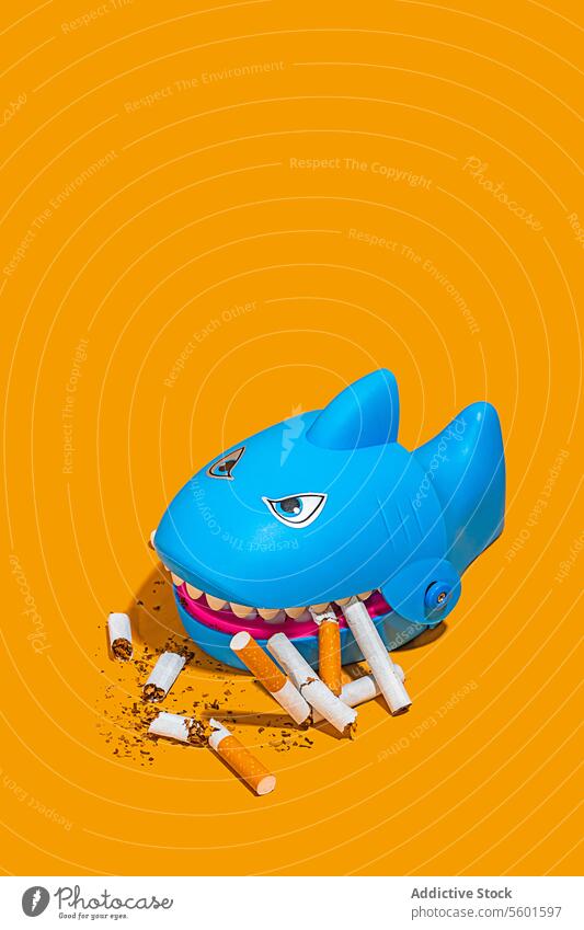 Hai-Spielzeug mit Zigarettenstummeln Haifisch Rauchen Gefahr umgebungsbedingt Einschlag Kunststoff blau pulsierend Kritik Gesundheit Sucht Habitus Abfall