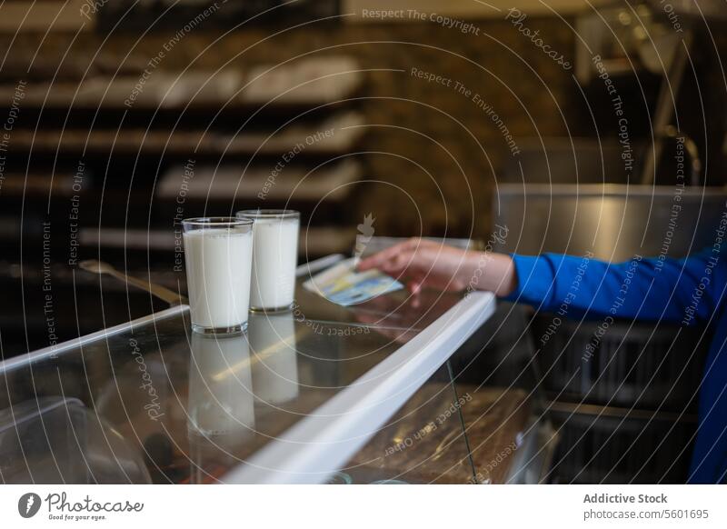 Unbekannte Person mit einem Zettel auf dem Tresen melken Glas Bäckerei Abfertigungsschalter Hand Molkerei frisch trinken Getränk bezahlen Laktose Kalzium