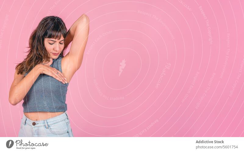 Frau bei einer Brust-Selbstuntersuchung auf rosa Hintergrund. Platz zum Kopieren bse Bewusstsein für Brustkrebs Brustkrebsmonat Prävention von Brustkrebs