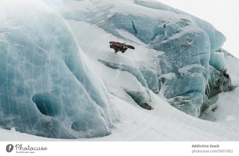 Aktiver Snowboarder springt von einem verschneiten Berg Person springen nachlässig Winter Urlaub Schnee Felsen Berge u. Gebirge Berghang genießen Schweizer