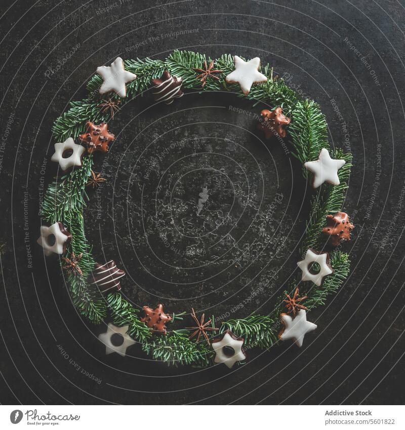 Weihnachten Kreis Rahmen mit Tannenkranz und Kekse auf dunklen Beton Küchentisch gemacht. Weihnachten Hintergrund mit Kopie Raum. Ansicht von oben.