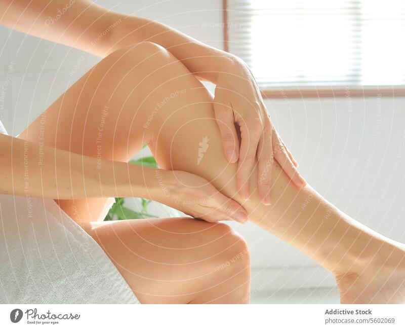Wellness- und Hautpflegekonzept. Junge Frau massiert ihre Beine nach der Enthaarung im Badezimmer. Pflege Konzept jung massierend danach Hygiene Maschine sanft