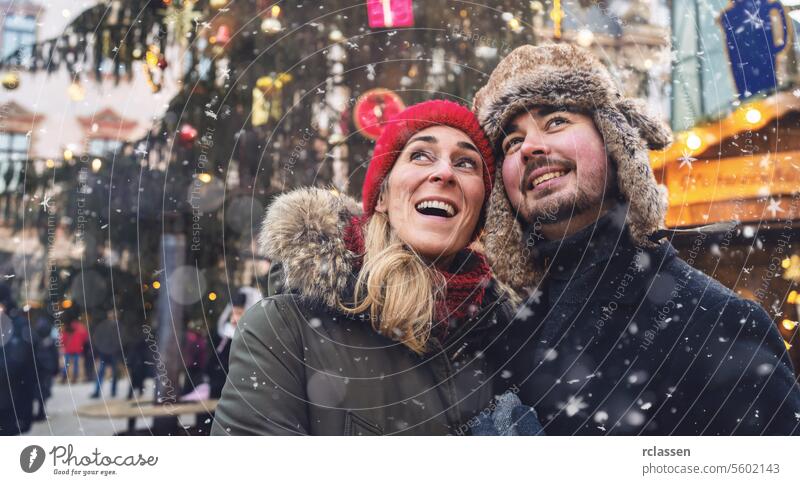 Frau und Mann auf dem Weihnachtsmarkt vor einem Baum Freunde Glühwein Vollbart Tourismus Datierung Fairness reisen Glück Paar Liebe Neujahr Schneefall Lächeln