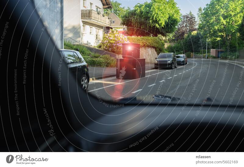 Blick aus dem Auto auf einen Blitzer auf der Straße, ein anderes Auto nähert sich, Wohngegend Radarkamera Verkehrssicherheit Wohnstraße herannahendes Auto