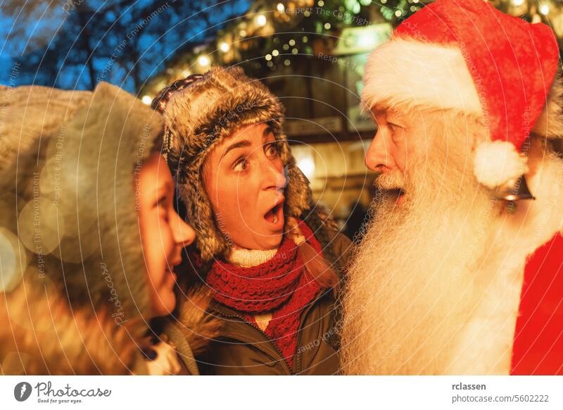 Frau und Kind vor Schreck und Freude über die Begegnung mit dem Weihnachtsmann auf einem Weihnachtsmarkt Tourist Frohe Weihnachten traditionell Glühwein Deutsch