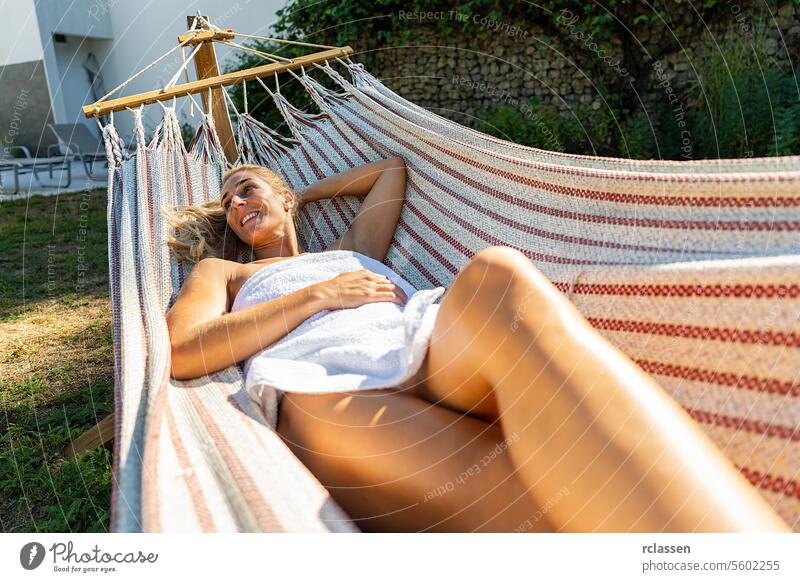 glückliche Frau entspannt sich in Spa und Wellness-Center auf einer Hängematte im Freien. Schönheitsbehandlung Konzept Bild Hotel Finnisch Sauna Handtuch