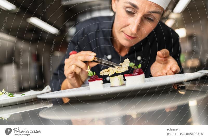 Chefkoch perfektioniert ein Gourmet-Dessert mit Reis-Chip-Topping Finishing Gericht, Dekoration Mahlzeit am Ende. Luxus-Hotel Kochen Konzept Bild. trendy