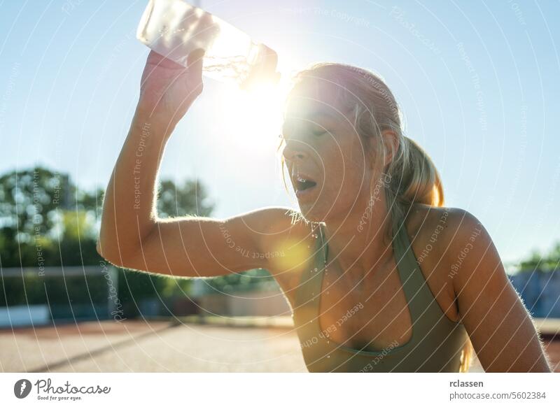 Frau gießt Wasser auf Gesicht nach dem Training, Sonne flare, Sportflasche, erfrischend Sonnenaufgang Athlet Hydratation Übung Abkühlung erwärmen im Freien