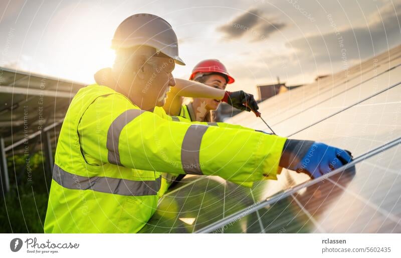 Team von Ingenieuren arbeiten an der Wartung von Sonnenkollektoren bei Sonnenuntergang. Alternative Energie ökologisches Konzept Bild. erneuerbare Ressource