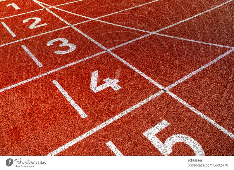 Nahaufnahme von Fahrbahnnummern auf einer roten Laufbahn, strukturierte Oberfläche, keine Menschen Fahrspur-Nummern Leichtathletik Sport rote Piste