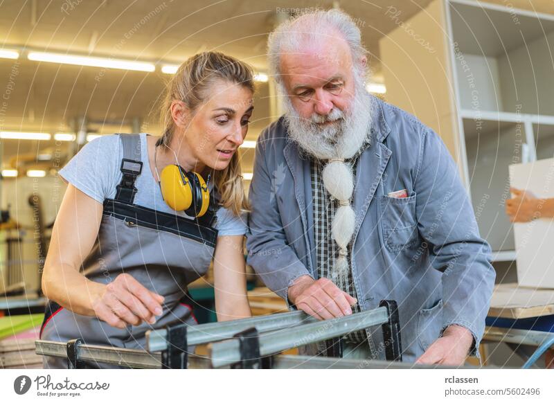 Tischlermeister und Lehrling konzentrieren sich auf das Einspannen von Holz in einer Werkstatt professionell Kunsthandwerker Hobelbank Möbelindustrie Arbeiter