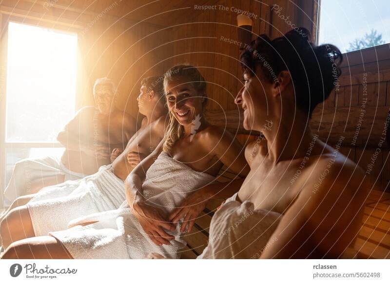 Menschen entspannen und schwitzen in der heißen Sauna, eingewickelt in ein Handtuch. Interieur der finnischen Sauna, klassische Holzsauna mit heißem Dampf. Russisches Bad. Entspannen im heißen Badehaus mit Dampf.