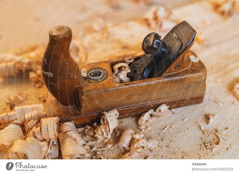 Altes Schreinerwerkzeug mit Holzspänen auf hölzernem Hintergrund altmodisch Schreinerwerkzeuge Schnitzerin Klinge Werkstatt Antiquität Schnitzereien Zimmerer
