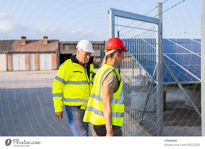 Männliche und weibliche Ingenieure in einem Solarkraftwerk an der Pforte zur Inspektion Besichtigung prüfen männlicher Ingenieur Ingenieurin Gate Besprechung