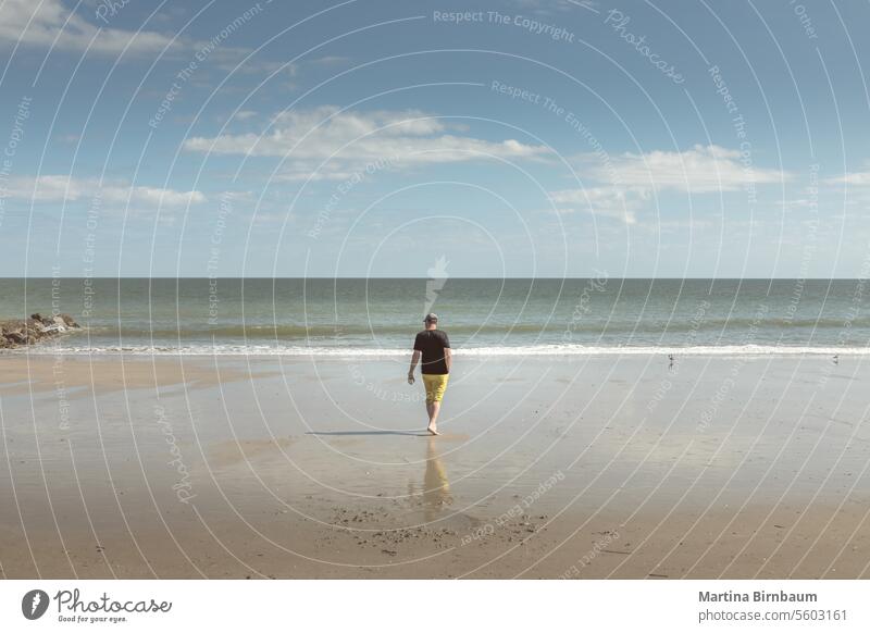 Kaukasischer Mann, der am Strand von Edisto Island, South Carolina, spazieren geht Kaukasier laufen Urlaub Sommer Tag Edisto-Strand edisto insel Landschaft