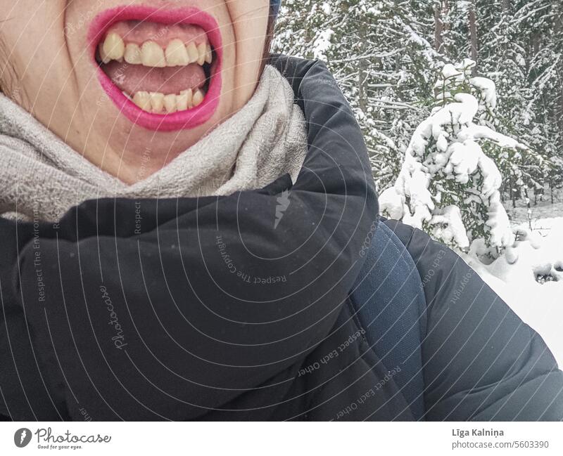 Lustiges Foto einer lächelnden Frau mit gelben, schiefen Zähnen in winterlicher Umgebung? Mund Gesicht Lippen rote Lippen Zunge lustig lachen Haut Mensch Winter