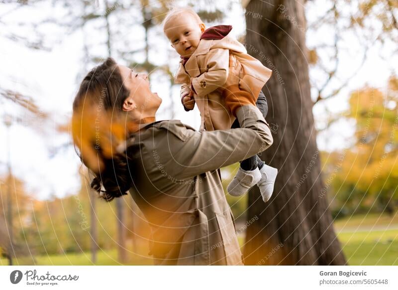 Junge Frau hält süßes Baby Mädchen im Herbst Park klein Kaukasier Mutter außerhalb Tochter Kind wenig Liebe niedlich Beteiligung Fröhlichkeit Zusammensein