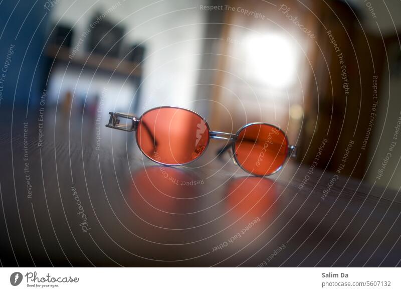 Modische rote Sonnenbrille in Großaufnahme stylisch modisch Nahaufnahme abschließen Zubehör Innenaufnahme Innenbereich im Innenbereich Innenaufnahmen Accessoire