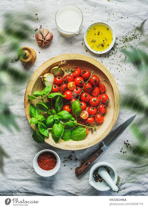 Italienisches Essen mit frischen Tomaten und Basilikumblättern auf einem Tisch mit anderen Zutaten, Ansicht von oben Italienische Küche Essen zubereiten Top