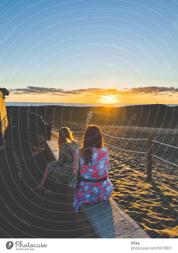 Zwei Frauen beobachten den Sonnenaufgang über den Dünen von Maspalomas auf Gran Canaria zwei Freundinnen morgen Sommerkleider Sonnenlicht Natur Menchen Urlaub
