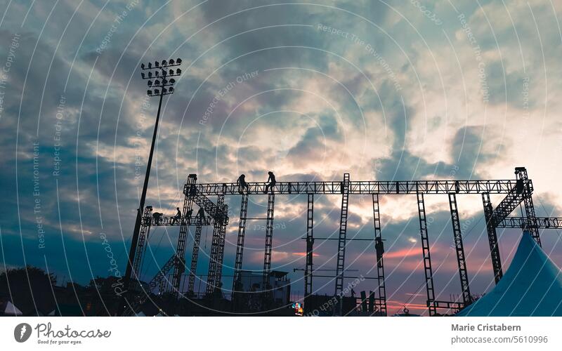Stadionlichter vor einem lebhaften Dämmerungshimmel mit bunten Wolken Lichter Silhouetten Abenddämmerung Himmel vertikal Industrie Gerüst Konstruktion Kraft