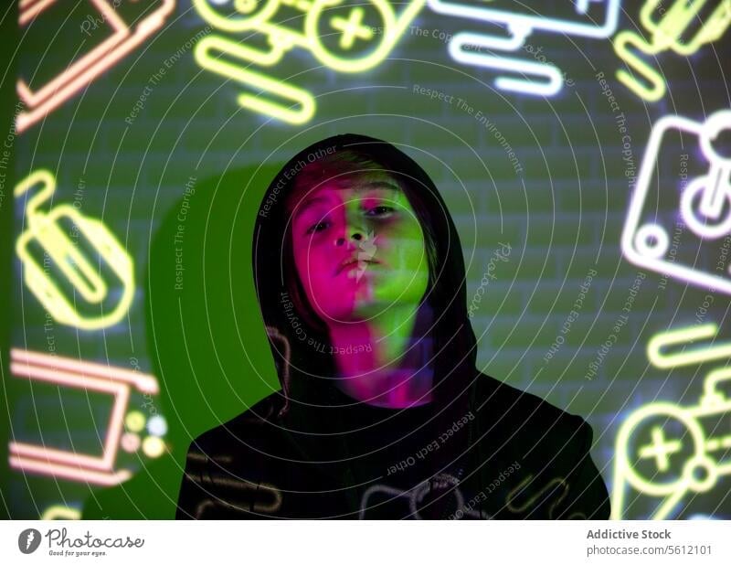 Jugendlicher Junge mit bunten Neongrafiken beleuchtet neonfarbig Licht farbenfroh Hintergrund Person beschaulich Ausdruck pulsierend graphisch Gesicht urban