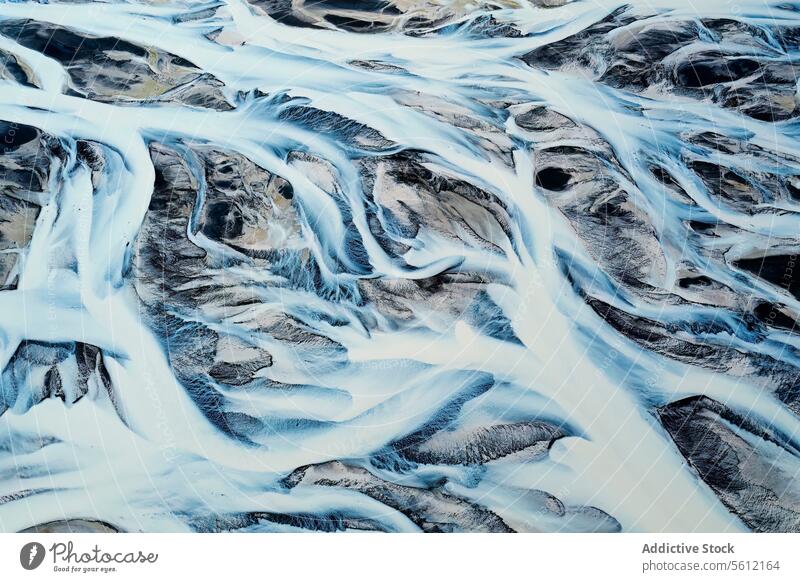Luftaufnahme eines schneebedeckten Flussgebiets in Island Flusseinzugsgebiet Schnee Muster Gelände Landschaft natürlich Winter kalt Wasserstraße strömen fließen