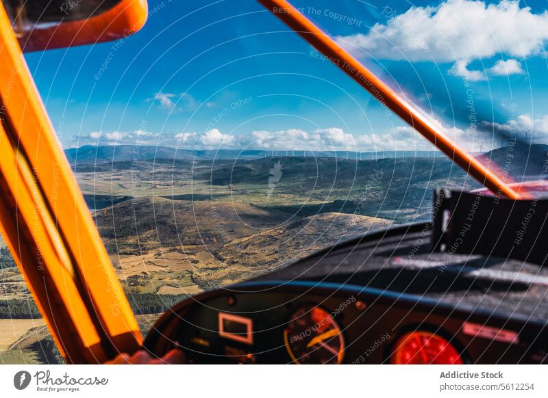 Blick aus dem Cockpit eines Flugzeugs auf eine weite Landschaft an einem bewölkten Tag Ansicht altehrwürdig Ebene blau Himmel Instrument Panel orange Struktur