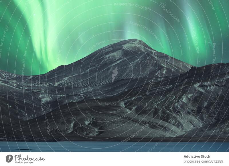 Polarlichter über einem schneebedeckten Berg in Island Nordlicht Nachthimmel Berge u. Gebirge Schnee Wildnis Naturphänomene Winter arktische Landschaft