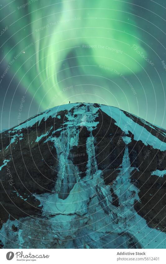 Nordlichter tanzen über einem verschneiten isländischen Berg Aurora borealis Island Nacht Himmel natürlich Anzeige Schnee Berge u. Gebirge Gipfel Winter grün