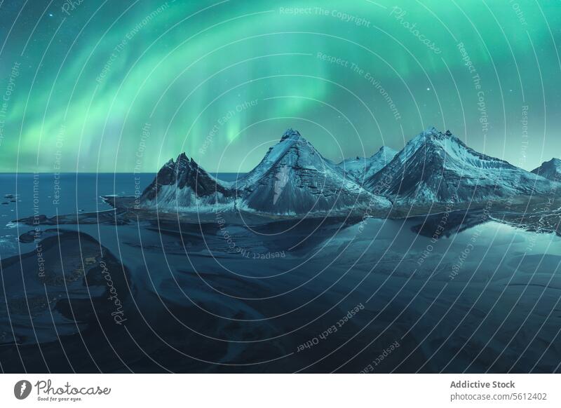 Mystische Nordlichter über verschneiten isländischen Gipfeln Island Berge u. Gebirge Schnee Nacht Himmel Naturwunder Landschaft arktische kalt Winter