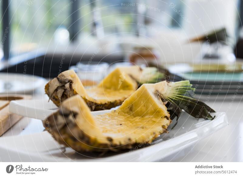 Geschnittene Ananasstücke mit Schale auf dem Küchentisch bei Tageslicht platzieren Scheibe Frucht tropisch exotisch gesunde Ernährung Teller reif Tisch Vitamin