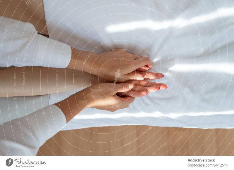 Hohe Winkel Ernte anonymen Therapeuten tun Akupunktur-Massage auf weiblichen Kunden die Hand auf komfortable weiße Bett im Spa-Salon während der Sitzung Frauen