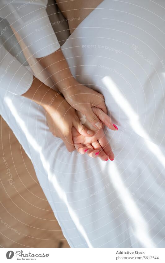 Hohe Winkel Ernte anonymen Therapeuten tun Akupunktur-Massage auf weiblichen Kunden die Hand auf komfortable weiße Bett im Spa-Salon während der Sitzung Frauen