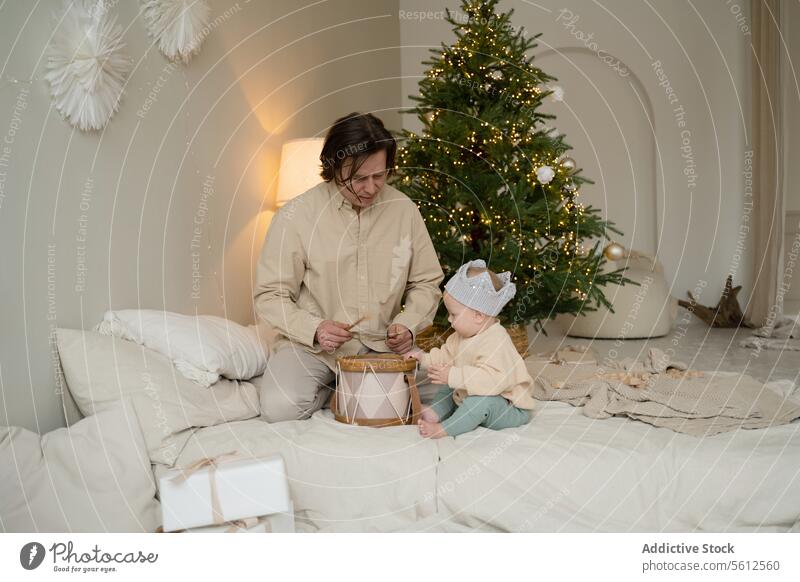 Vater und Kleinkind genießen die Weihnachtszeit zu Hause Weihnachten heimwärts gemütlich Dekoration & Verzierung Spielen Trommel Krone Kind Feiertag Raum