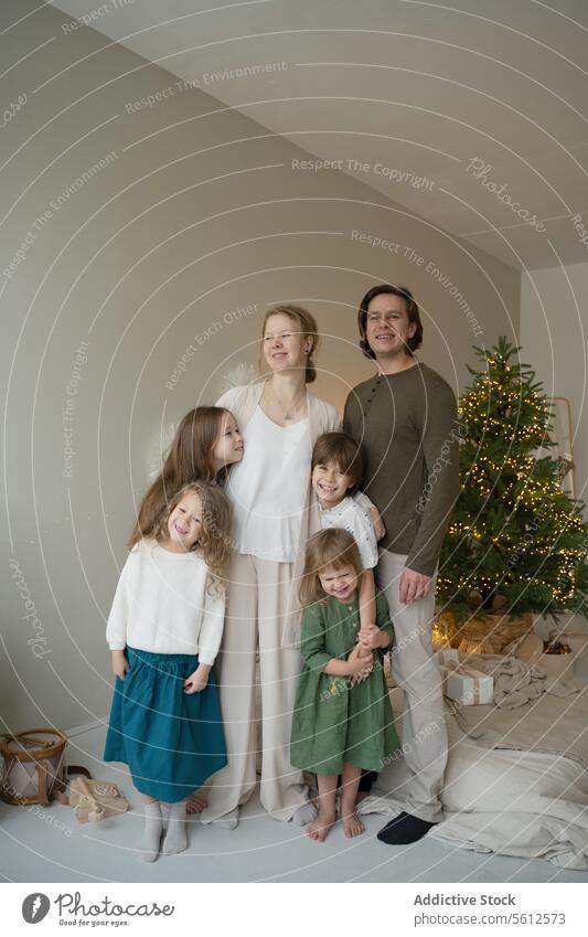 Familienporträt mit Weihnachtsbaumkulisse Porträt Weihnachten Feiertag festlich Glück Foto Baum Dekor Wärme Eltern Kinder Zusammengehörigkeitsgefühl Moment