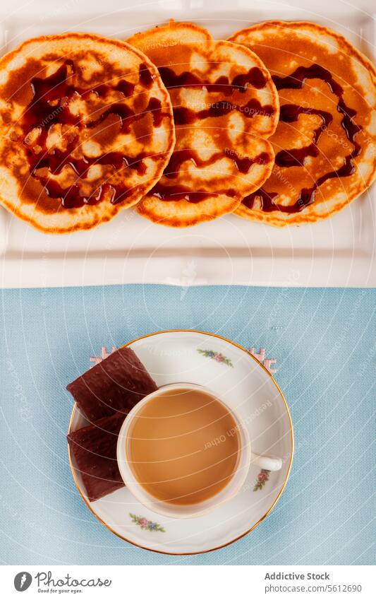 Frühstück mit Kaffee und gestapelten Waffeln auf blau Sirup Tasse Untertasse melken Hintergrund Overhead Ansicht Stapel Nieselregen Morgen Mahlzeit Lebensmittel
