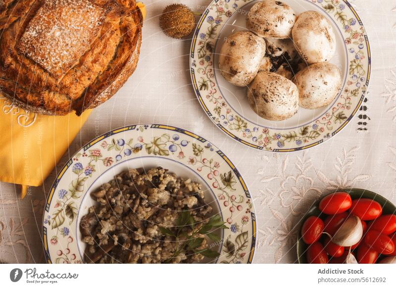 Rustikal gedeckter Tisch mit traditionellen Gerichten rustikal Einstellung Risotto Lebensmittel hausgemachte frisch Zutaten Teller Pilz Tomate Gewebe Textil