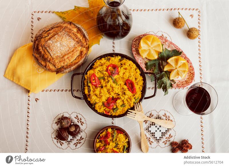 Authentische spanische Paella, serviert mit Brot und Wein spanische Küche traditionell Reis Meeresfrüchte Pfanne Ansicht von oben Tischwäsche Muster Mahlzeit