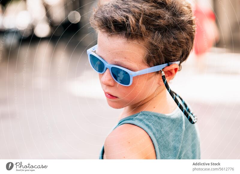 Ruhiger Junge mit Schutzbrille schaut weg niedlich Sonnenbrille Gesicht Wegsehen verschwommener Hintergrund Nahaufnahme ernst Tanktop blau attraktiv Windstille